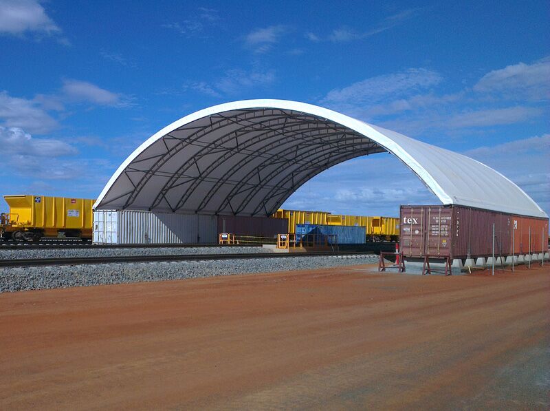Fabric Shelter on Rail Yard A container-mounted fabric shelter located in a rail yard, providing cover for logistics operations.