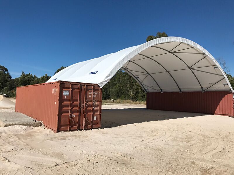Red Container-Mounted Shelter A large fabric shelter supported by red containers, ideal for industrial or storage purposes.