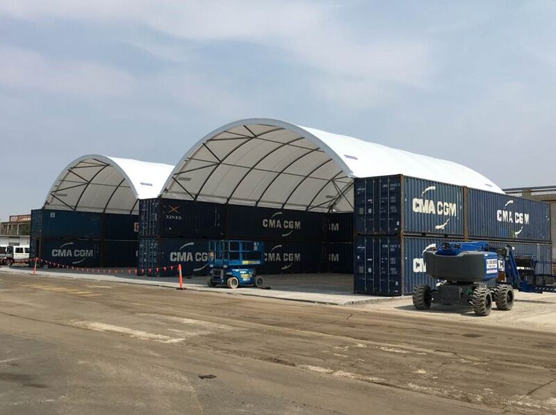Container-Mounted Dual Fabric Shelters Two large container-mounted fabric shelters providing spacious covered areas for storage or industrial activities.