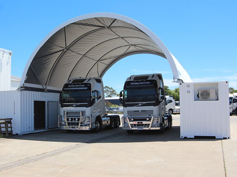 Truck Shelter with Container Support A fabric shelter providing cover for trucks, supported by containers with integrated storage solutions.
